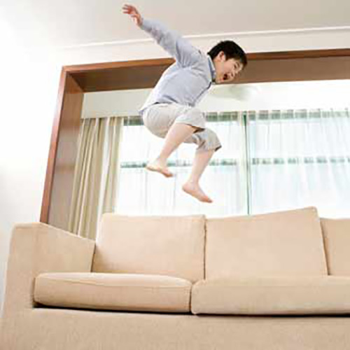 Couch protector spray has been applied to protect couch from jumping boy